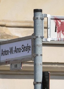 Ein Straßenschild, das mit dem Namen "Anton Wilhelm Amo Straße" überkleppt ist