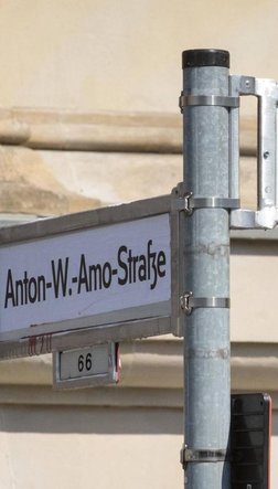 Ein Straßenschild, das mit dem Namen "Anton Wilhelm Amo Straße" überkleppt ist