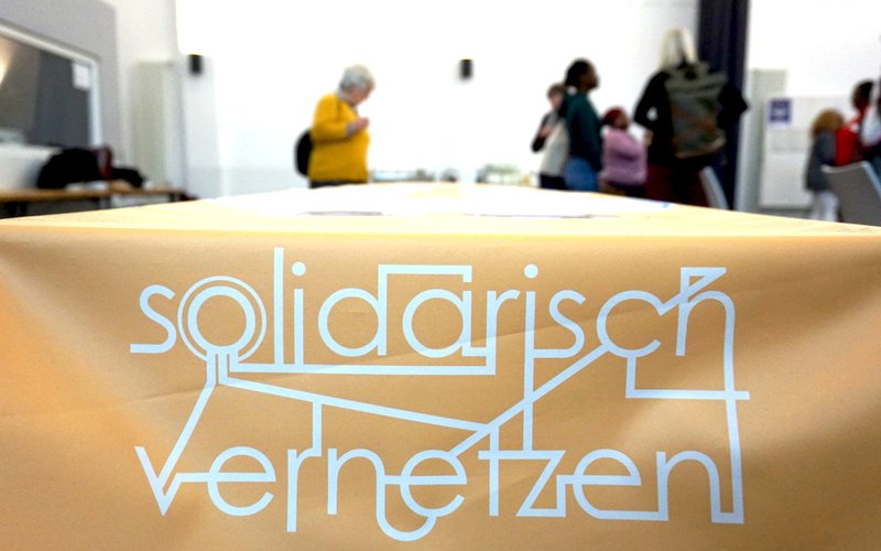 Auf einer Tischdecke steht Solidarisch vernetzen