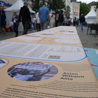 Eine Gruppe Menschen steht vor dem EU Parlament vor einem großen Schild, auf dem "Together for Democracy" steht