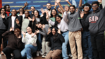Eine Gruppe von ca. 20 jungen Menschen lächelt in die Kamera