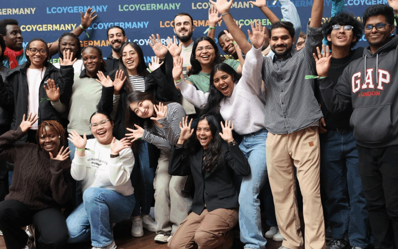 Eine Gruppe von ca. 20 jungen Menschen lächelt in die Kamera