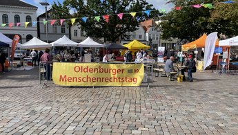 Ein großer Banner "Oldenburger Menschenrechtstag" auf dem Marktplatz