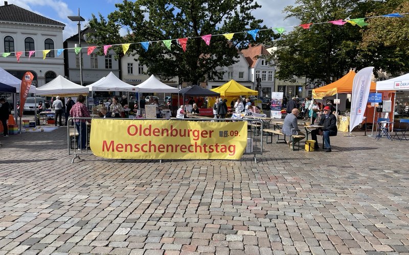 Ein großer Banner "Oldenburger Menschenrechtstag" auf dem Marktplatz