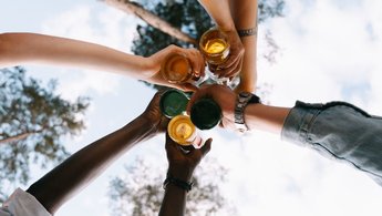 Arme von unterschiedlichen Menschen die sich zu prosten - Perspektive von unten