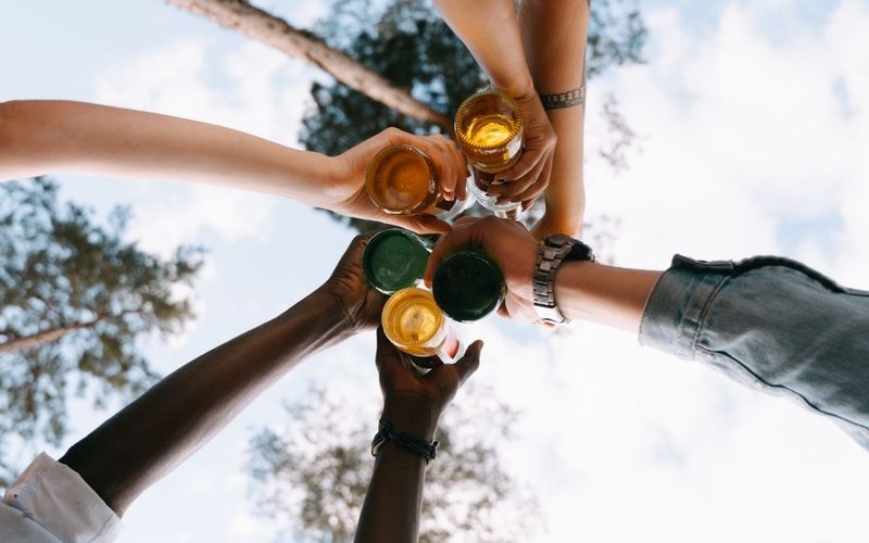 Arme von unterschiedlichen Menschen die sich zu prosten - Perspektive von unten