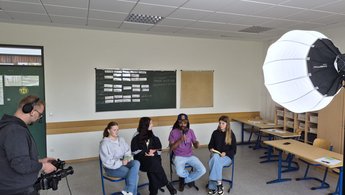 Schülerinnen tauschen sich mit Südgast im Klassenzimmer aus
