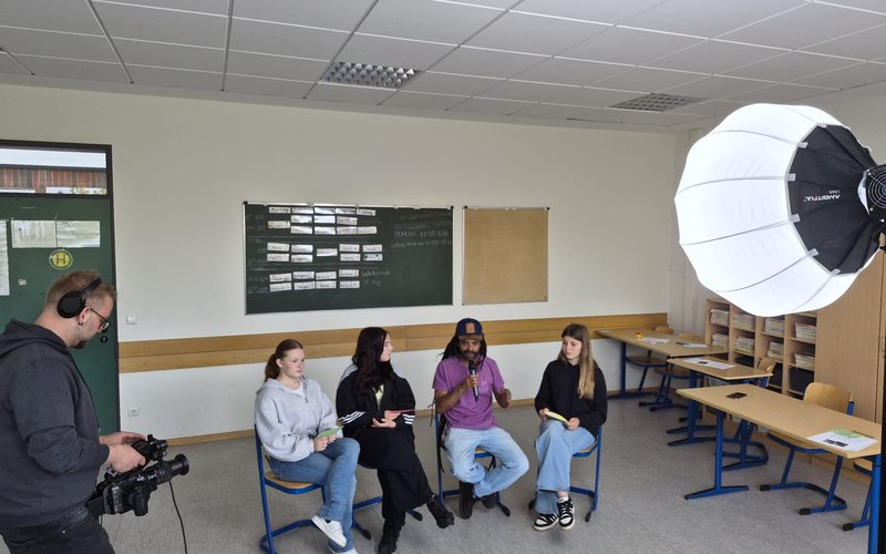 Schülerinnen tauschen sich mit Südgast im Klassenzimmer aus