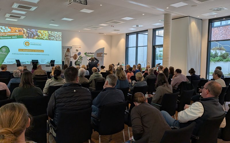 Menschen sitzen vor einer Bühne