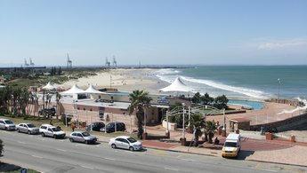 Eine breite Straße vor einem Strand, blauer Himmel