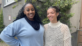 Thamie und Laila stehen lachend vor einem Haus