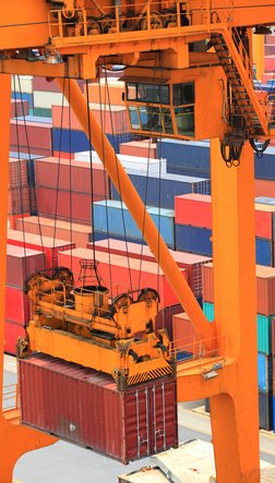 Ein Container wird auf ein Containerschiff geladen